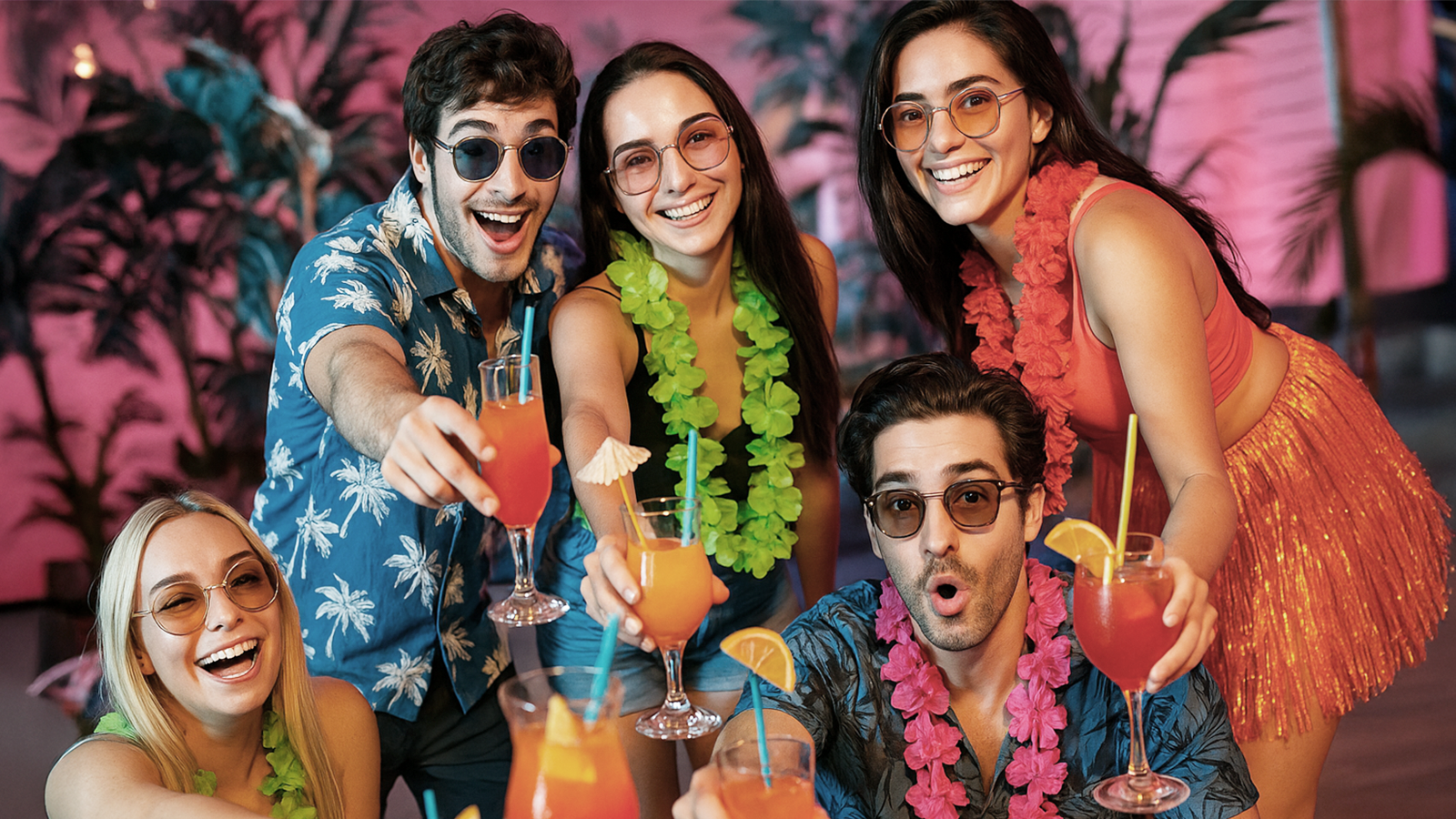 Gruppe junger Menschen mit bunten Cocktails und Hawaii-Ketten feiert ausgelassen – tropische Geburtstagsstimmung mit Hanseatic DJs