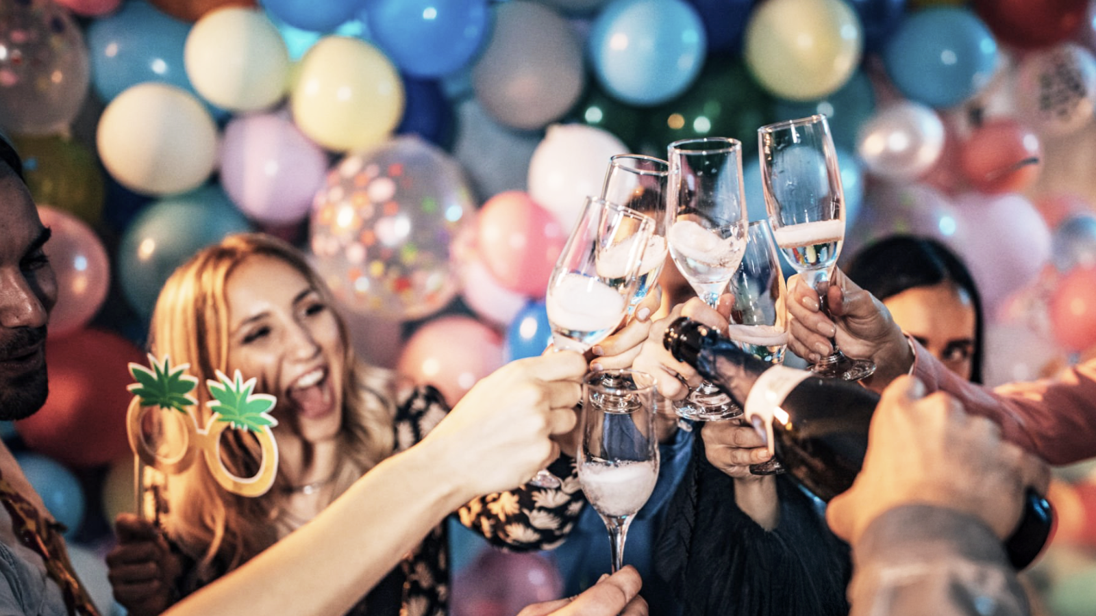 Geburtstagsgäste stoßen mit Sektgläsern an, umgeben von bunten Luftballons – fröhliche Geburtstagsfeier mit Hanseatic DJs und festlicher Deko