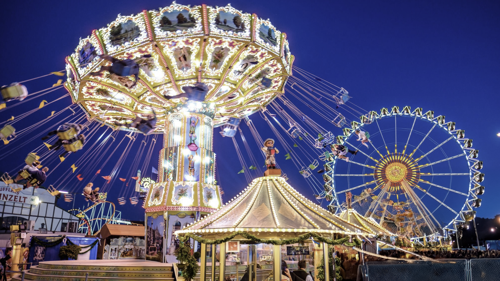 Beleuchtetes Kettenkarussell und Riesenrad bei Nacht auf einem Stadtfest – festliche Stimmung und Musik mit Hanseatic-DJs