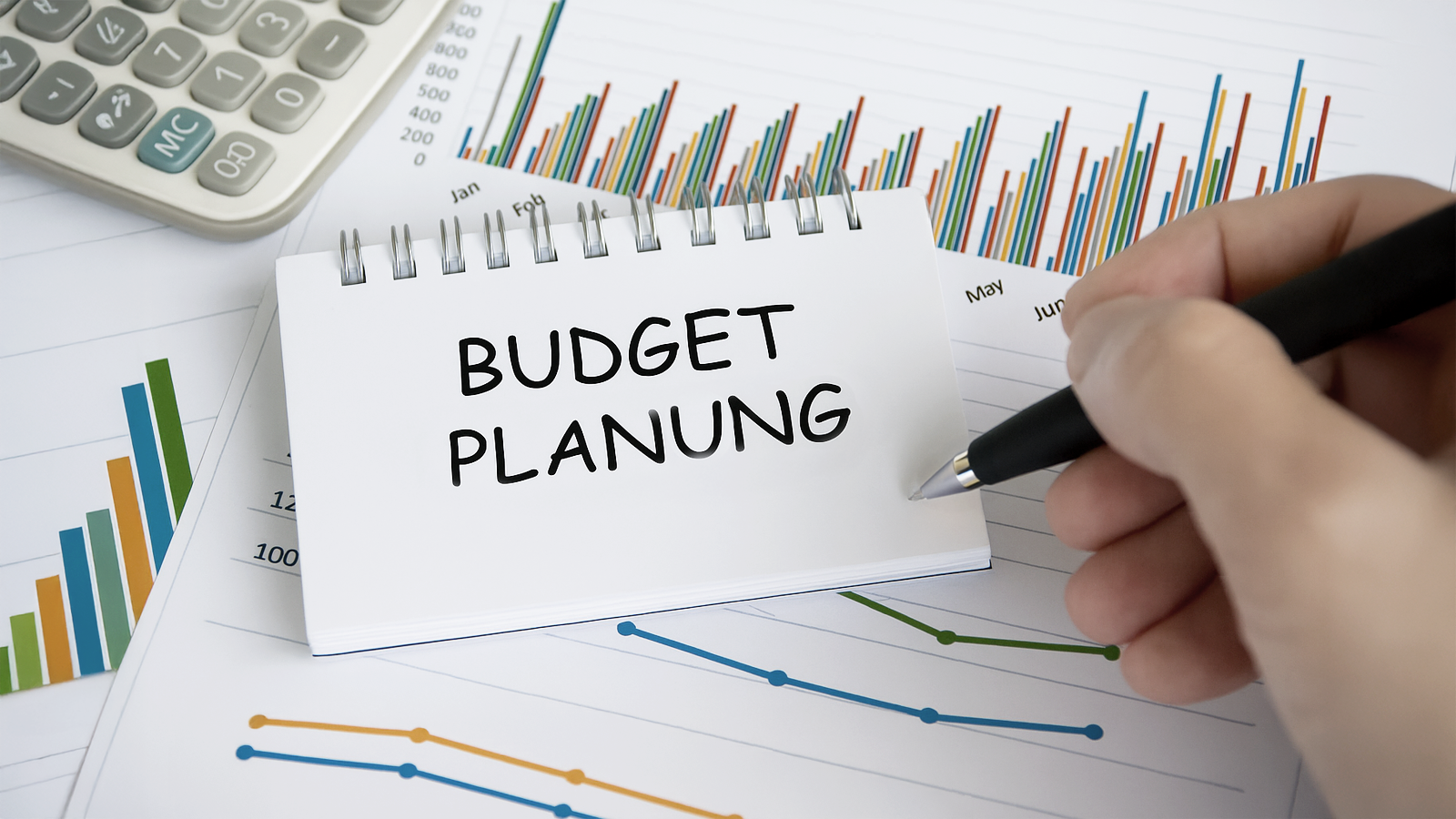 Notiz mit „Budget Planung“ auf Finanzunterlagen und Diagrammen – visuelle Darstellung der Hochzeitsbudgetplanung mit Event-DJ Tom Hendrics