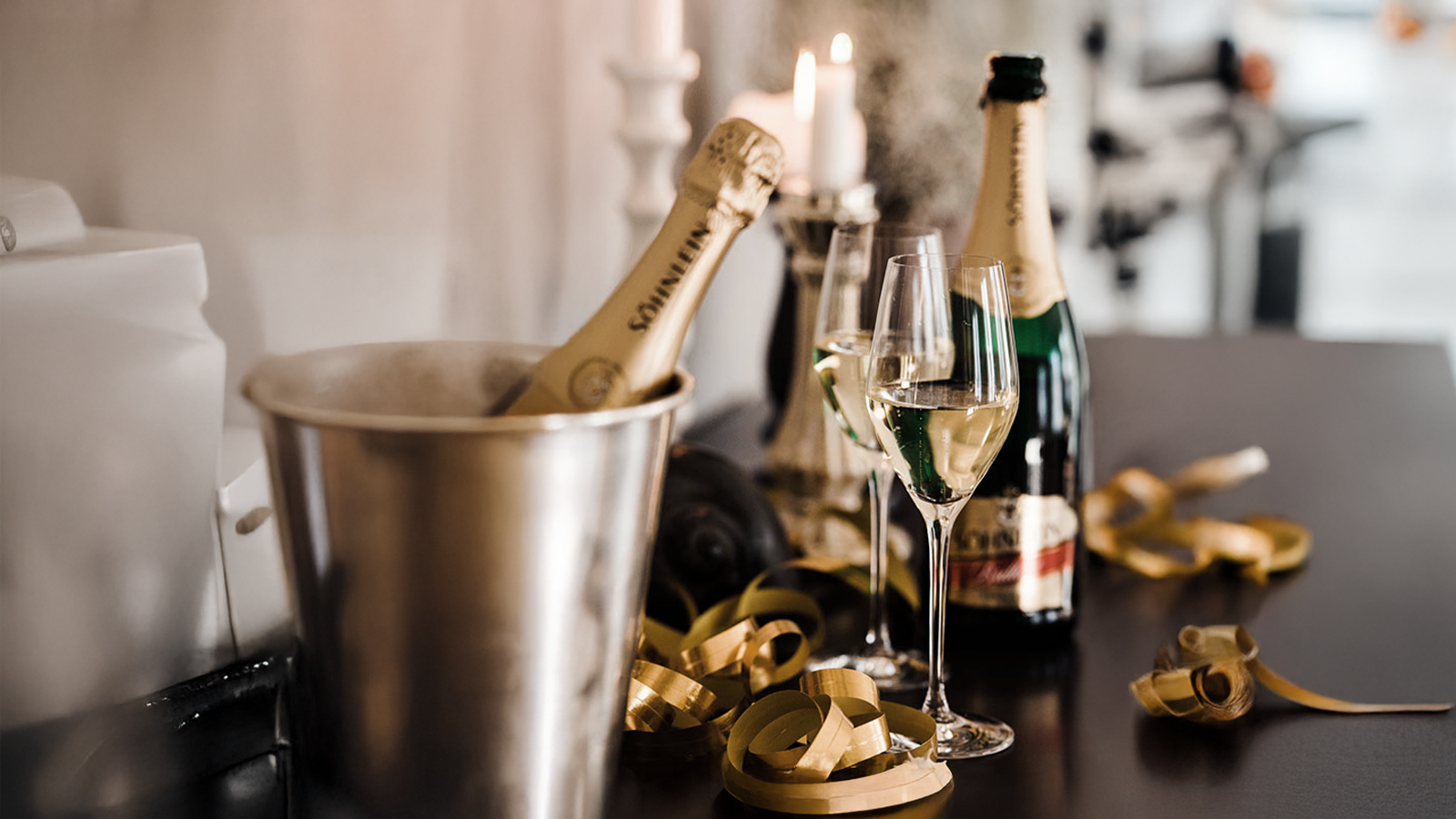 Die perfekte Weihnachtsfeier planen – Catering & Event-Tipps für Firmenveranstalter Champagnerflaschen, Kerzen und festliche Deko auf einem Tisch – stilvolles Catering für Firmen-Weihnachtsfeiern mit Event-DJ Tom Hendrics